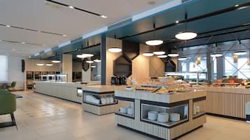 A modern buffet setup with multiple serving stations, a clean tiled floor, and contemporary lighting fixtures.