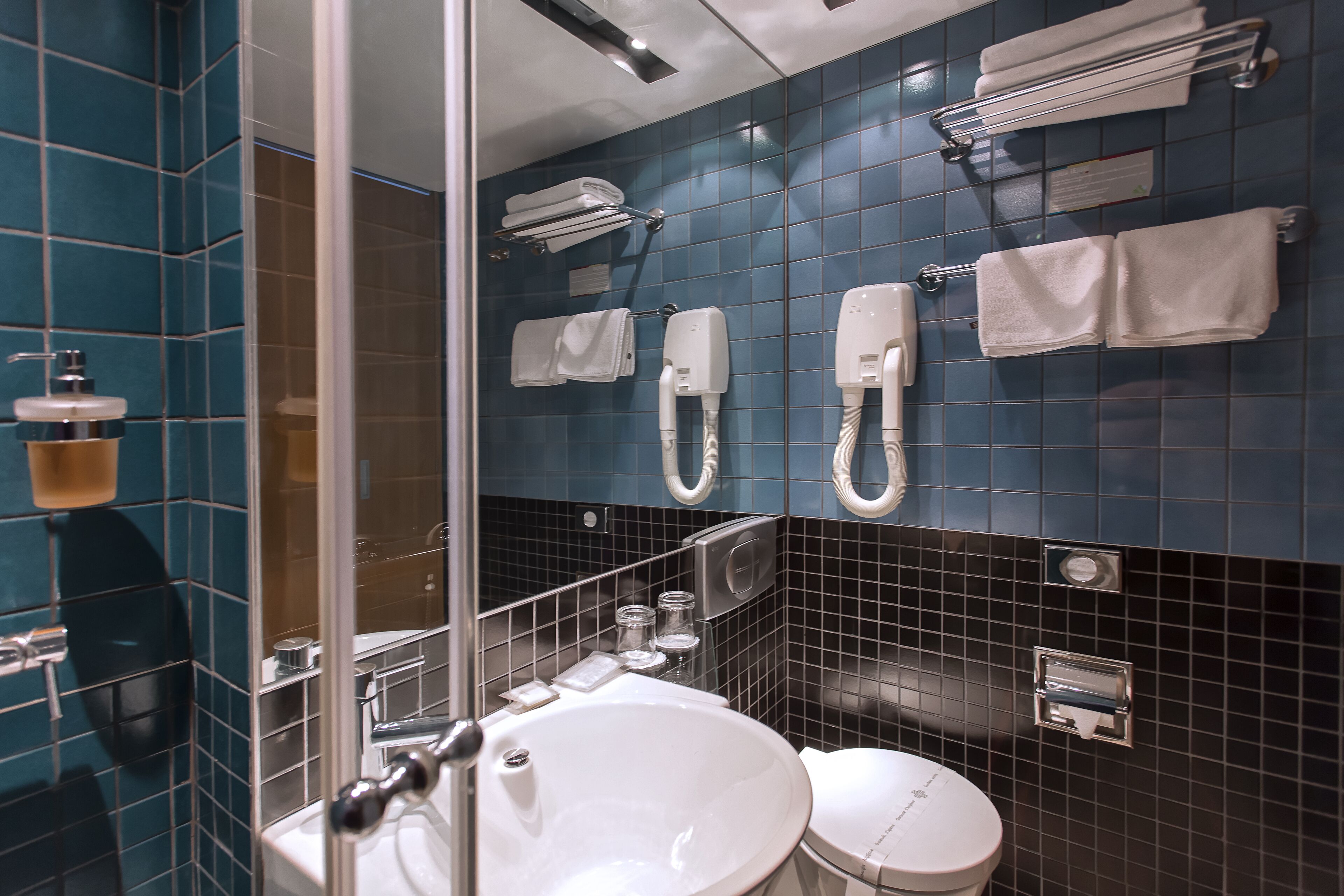 Une salle de bain équipée d’un lavabo, de toilettes et d’un porte-serviettes.