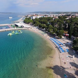 On the beach, white sand, sun-loungers, beach umbrellas