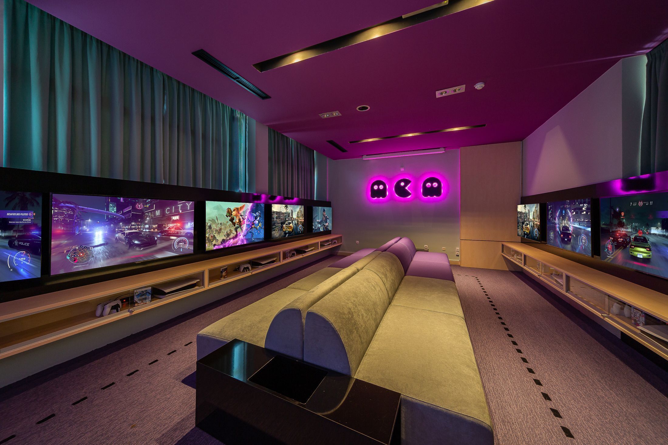 A modern living room with a large flat-screen TV, a sofa, and a gaming console.