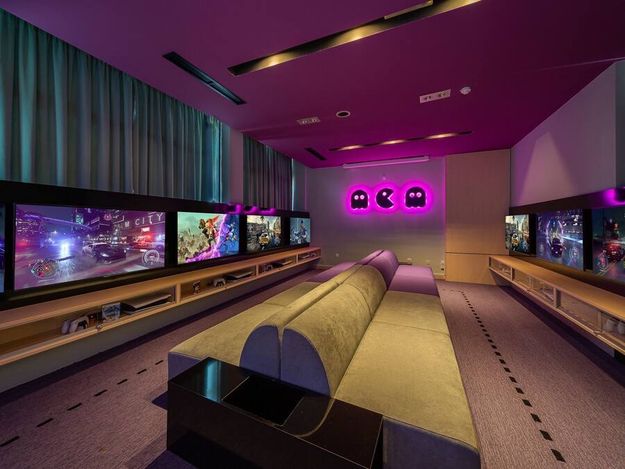 A modern living room with a large flat-screen TV, a sofa, and a gaming console.