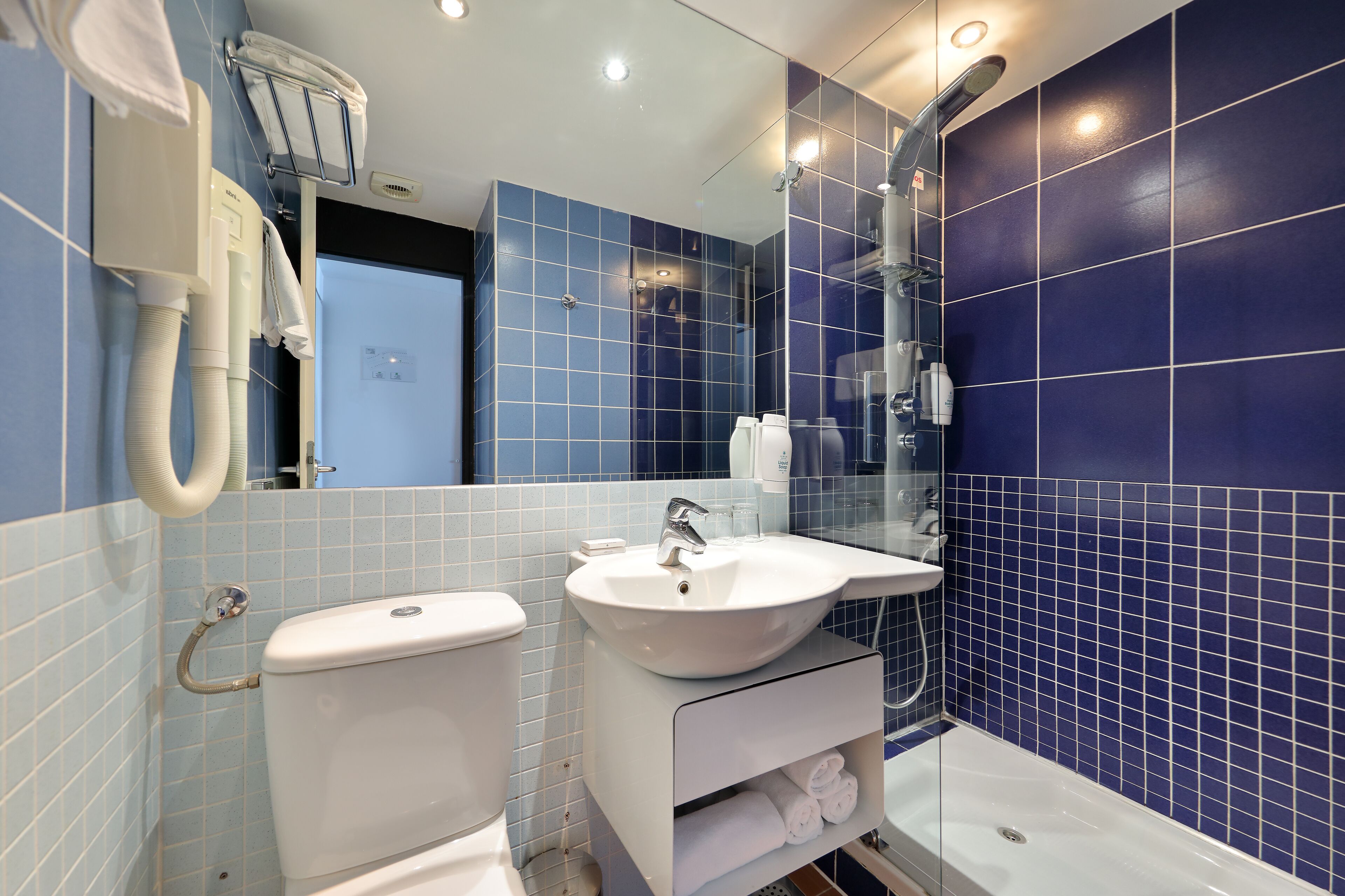 A modern bathroom with a toilet, sink, and shower.