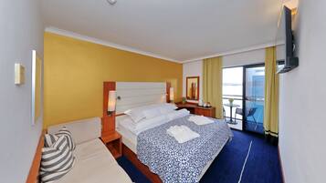 Una habitación de hotel con cama, sofá, escritorio y televisión.