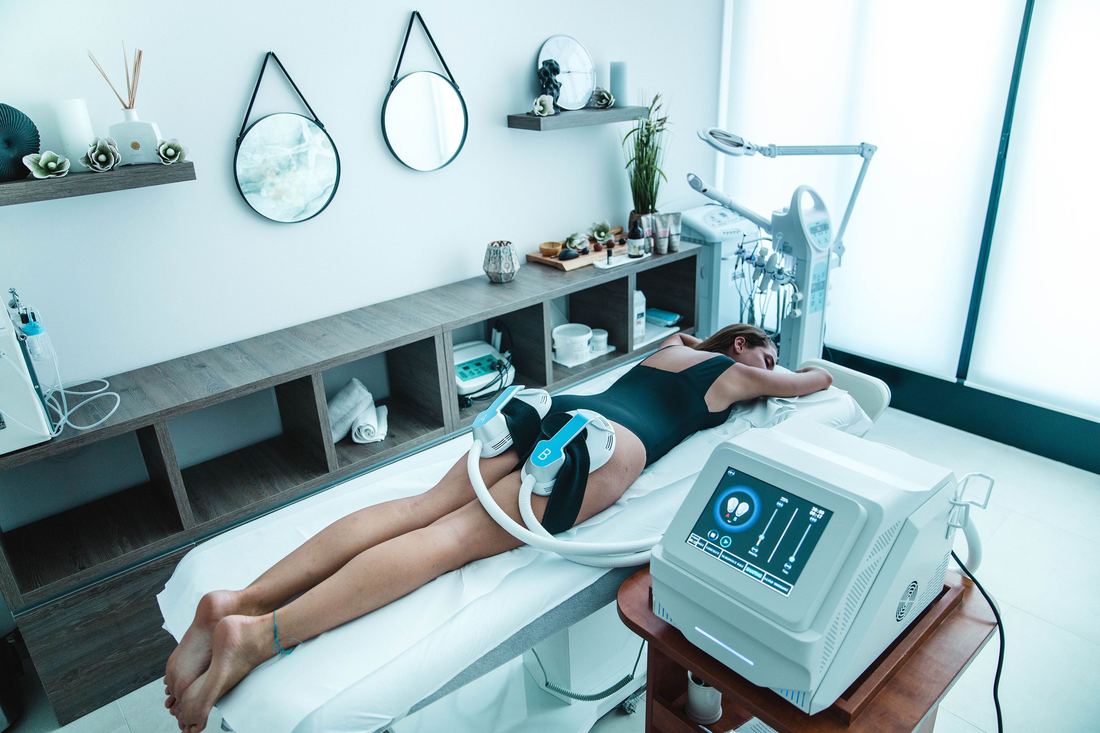 Un cuarto de tratamientos médicos con un paciente acostado en una cama, conectado a un equipo médico, y una silla dental con luz.