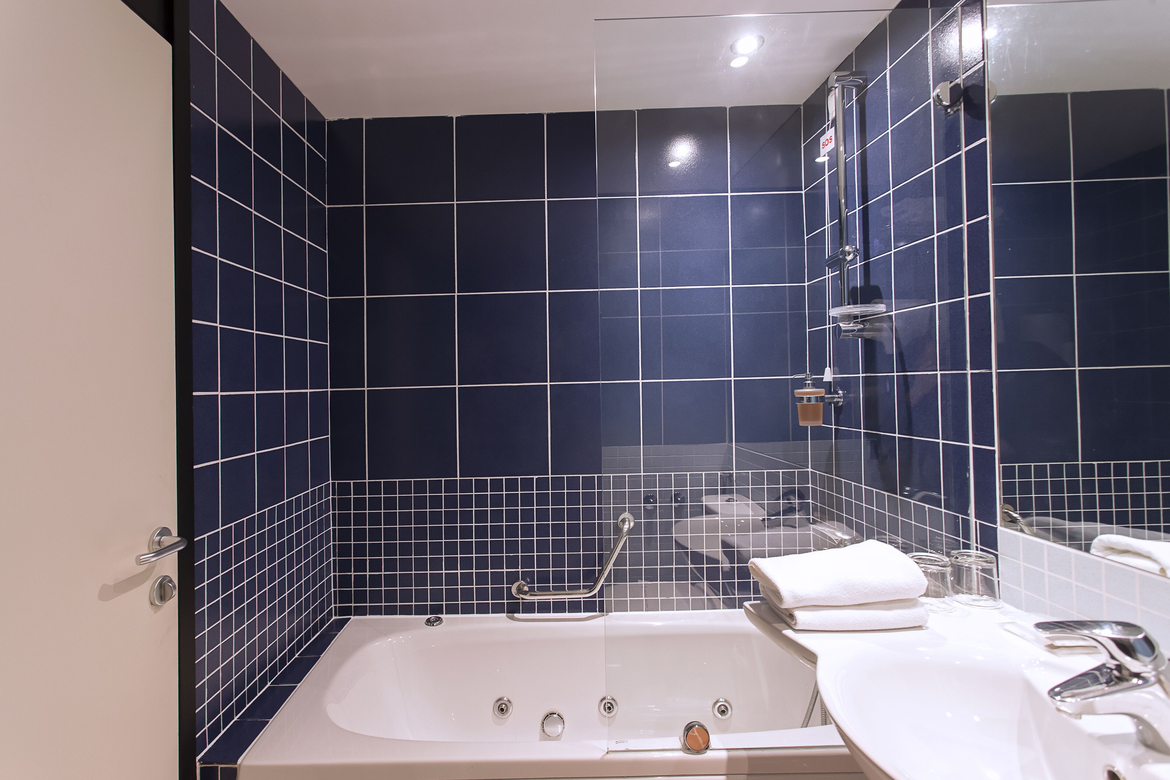 A bathroom with a bathtub, a sink, and a mirror.