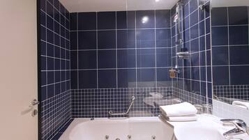 Une salle de bain avec une baignoire, un lavabo et un miroir.