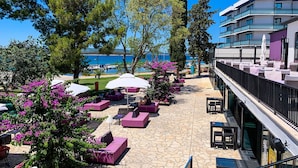 Una terraza con asientos al aire libre, piso de piedra y vista al mar.