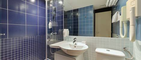 Une salle de bain moderne avec des carreaux bleus, un lavabo blanc et une baignoire.