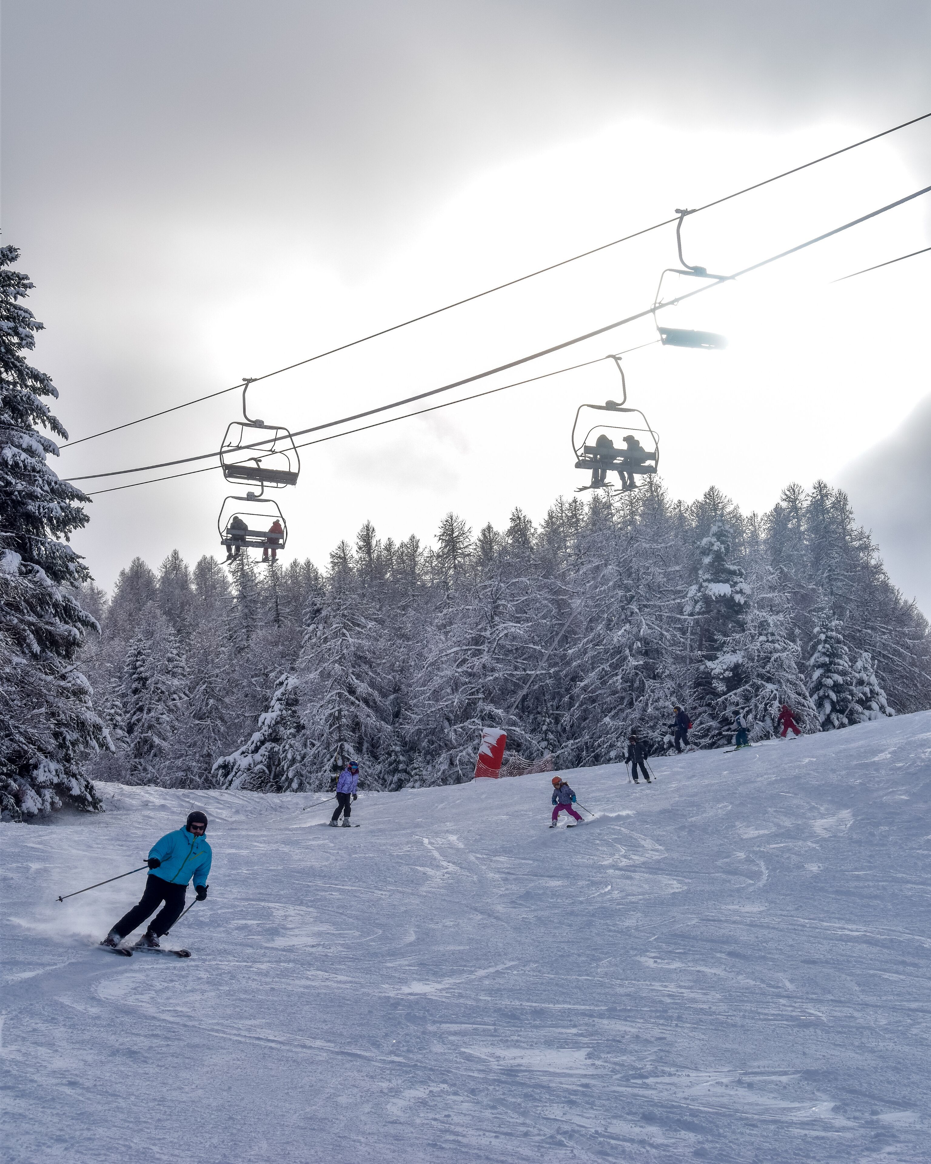 A ski slope with skiers and a ski lift.