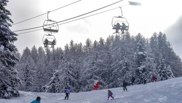 A ski slope with skiers and a ski lift.