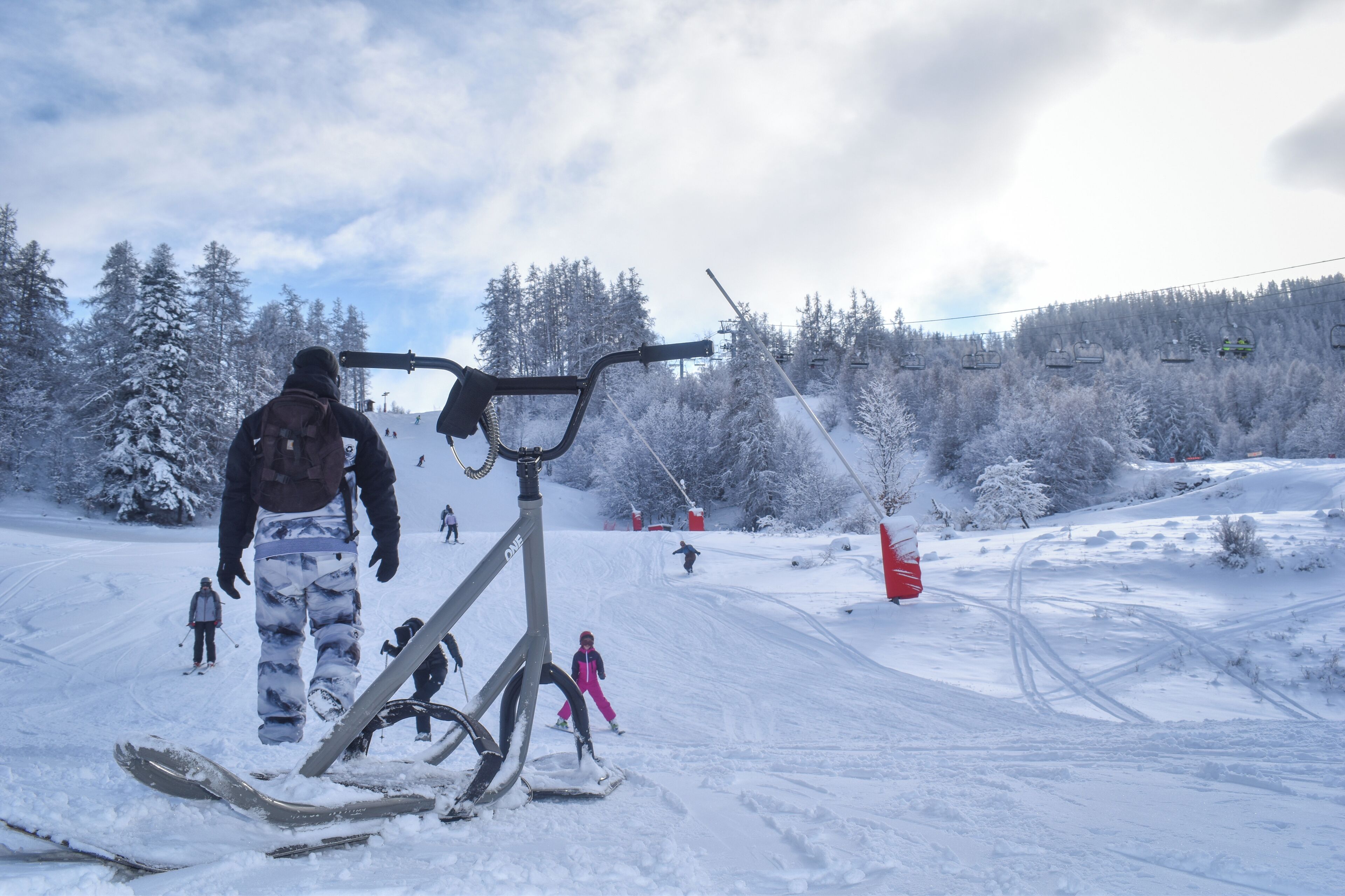A snowy ski slope with a ski lift and skiers.