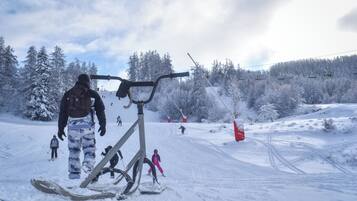 A snowy ski slope with a ski lift and skiers.