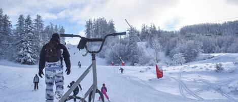 A snowy ski slope with a ski lift and skiers.