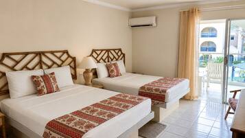 Habitación de hotel con dos camas, un balcón y aire acondicionado.