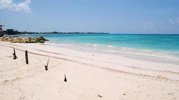 Una playa cerca, arena blanca, camas de playa gratis