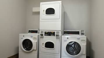 A laundry room with three stacked washing machines.
