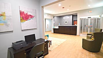A reception area with a desk, chairs, and artwork on the walls.