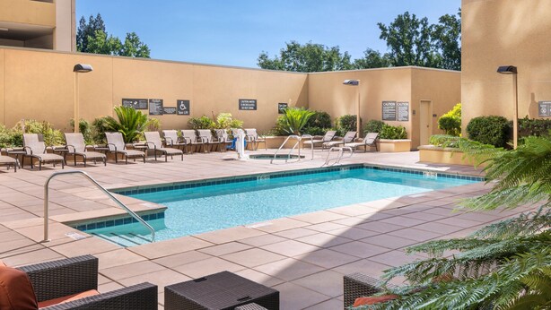 Un espace piscine avec des chaises longues et une petite piscine.