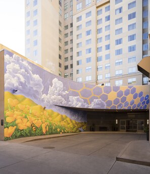 Een gebouw met een muurschildering van bloemen en wolken.