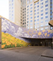 Un edificio con un mural de flores y nubes en la pared.