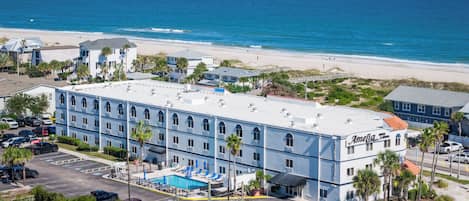 Un hotel con piscina, cerca de una playa y vistas al océano.
