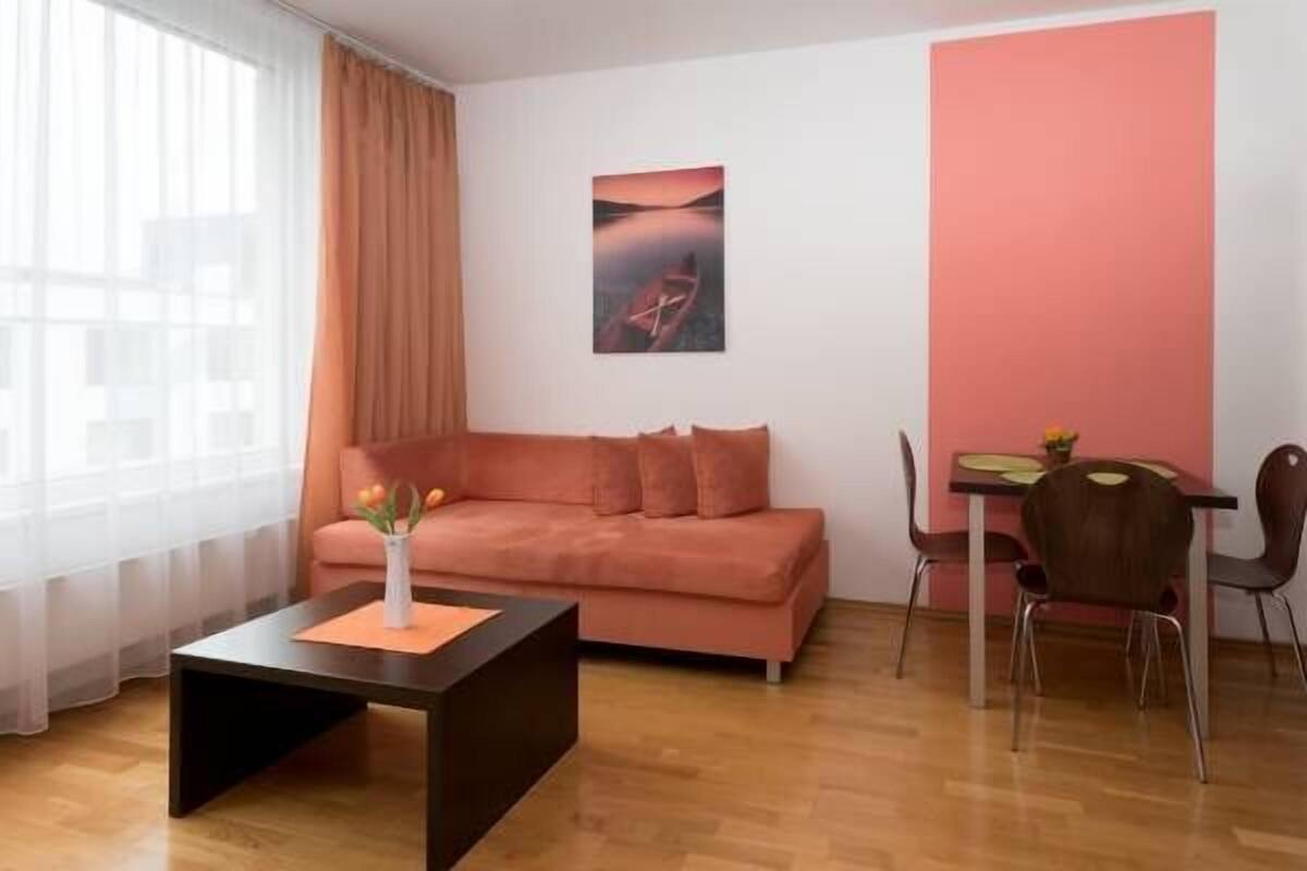 Ein modernes Wohnzimmer mit einer Couch, einem Couchtisch und einem Essbereich mit Stühlen und einem Tisch.