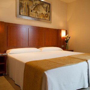Ein Hotelzimmer mit einem großen Bett, einem Holz-Kopfteil, einem Nachttisch mit einer Lampe und einem Gemälde an der Wand.