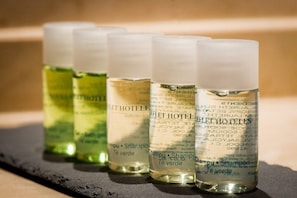 Four bottles of hotel shampoo on a black surface. - Leflet Valme (Dos Hermanas)