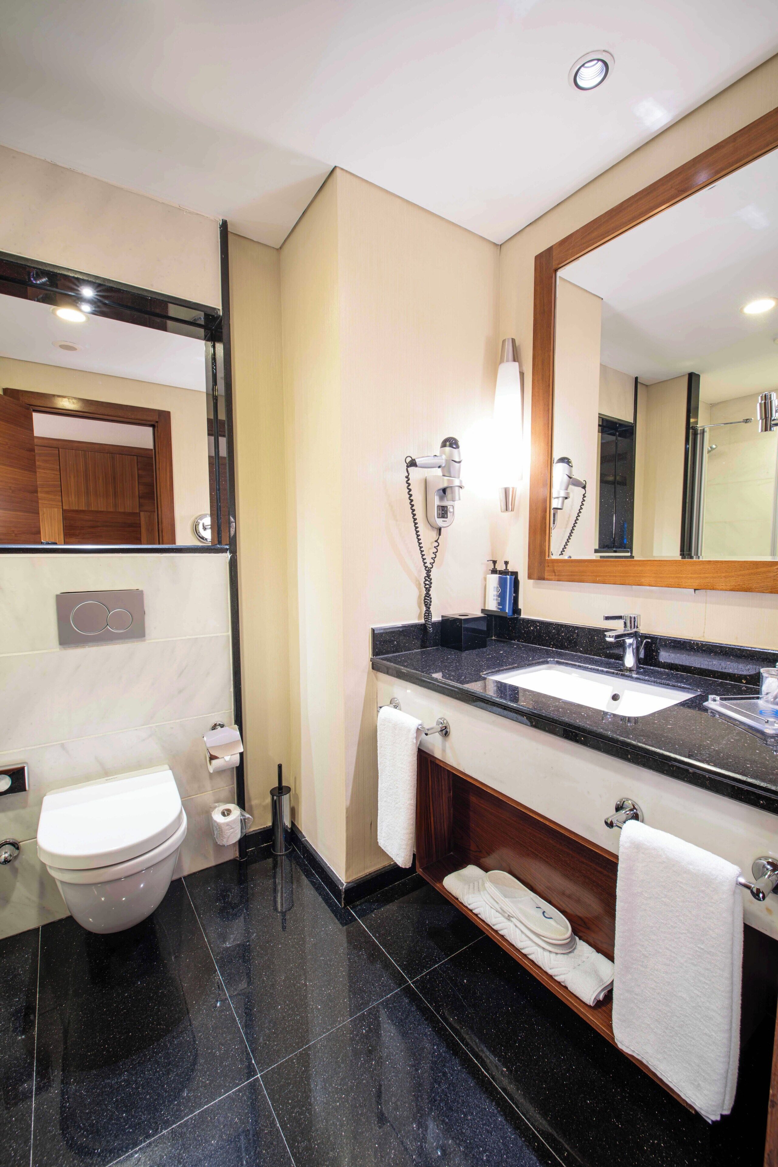 Un baño moderno con inodoro, lavabo y espejo.