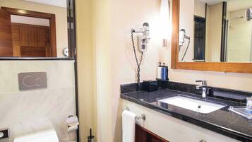Un baño moderno con inodoro, lavabo y espejo.