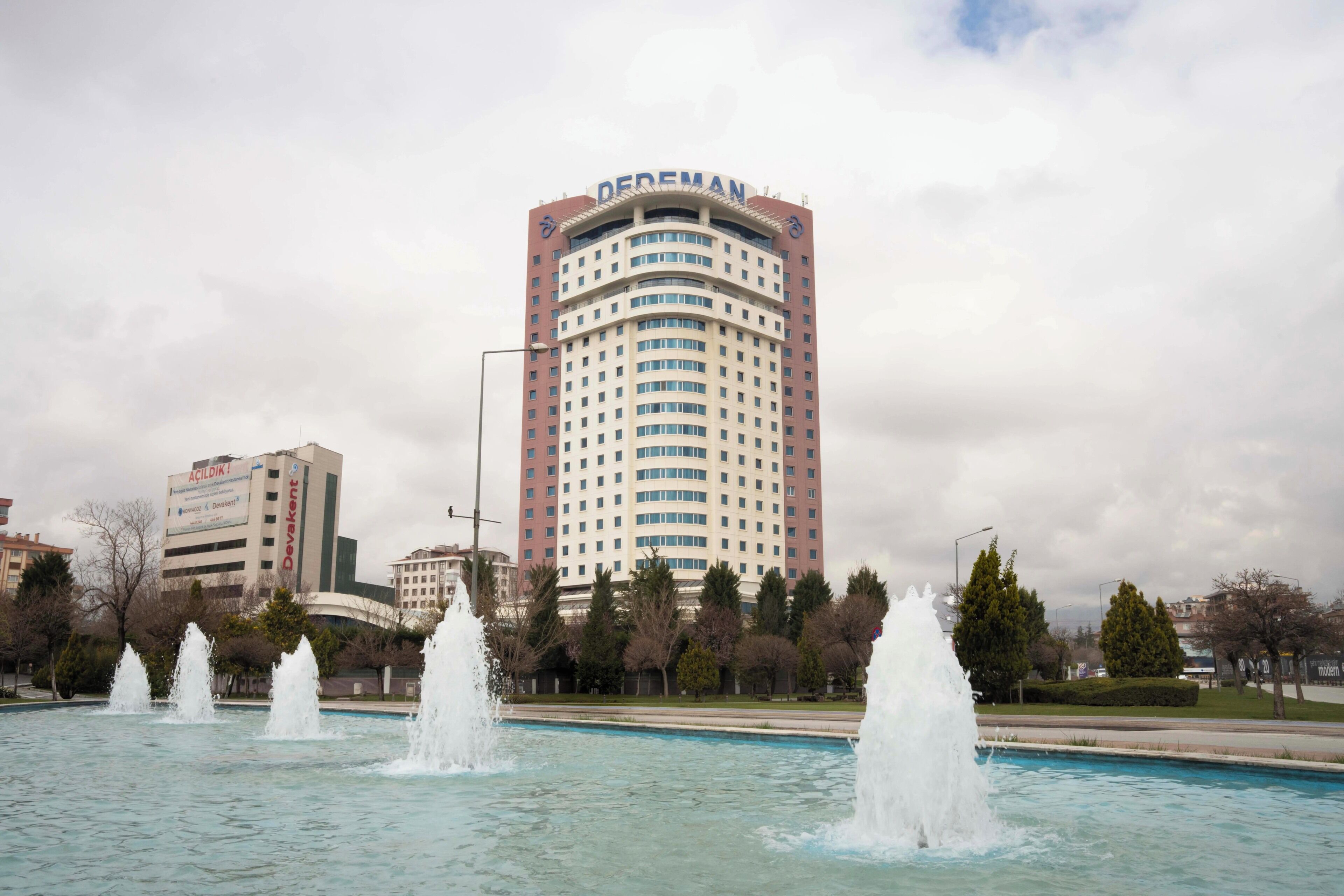 A hotel with a curved facade, multiple floors, and a prominent sign at the top.
