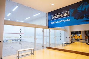 A gym with a large mirror, exercise equipment, and a bench.