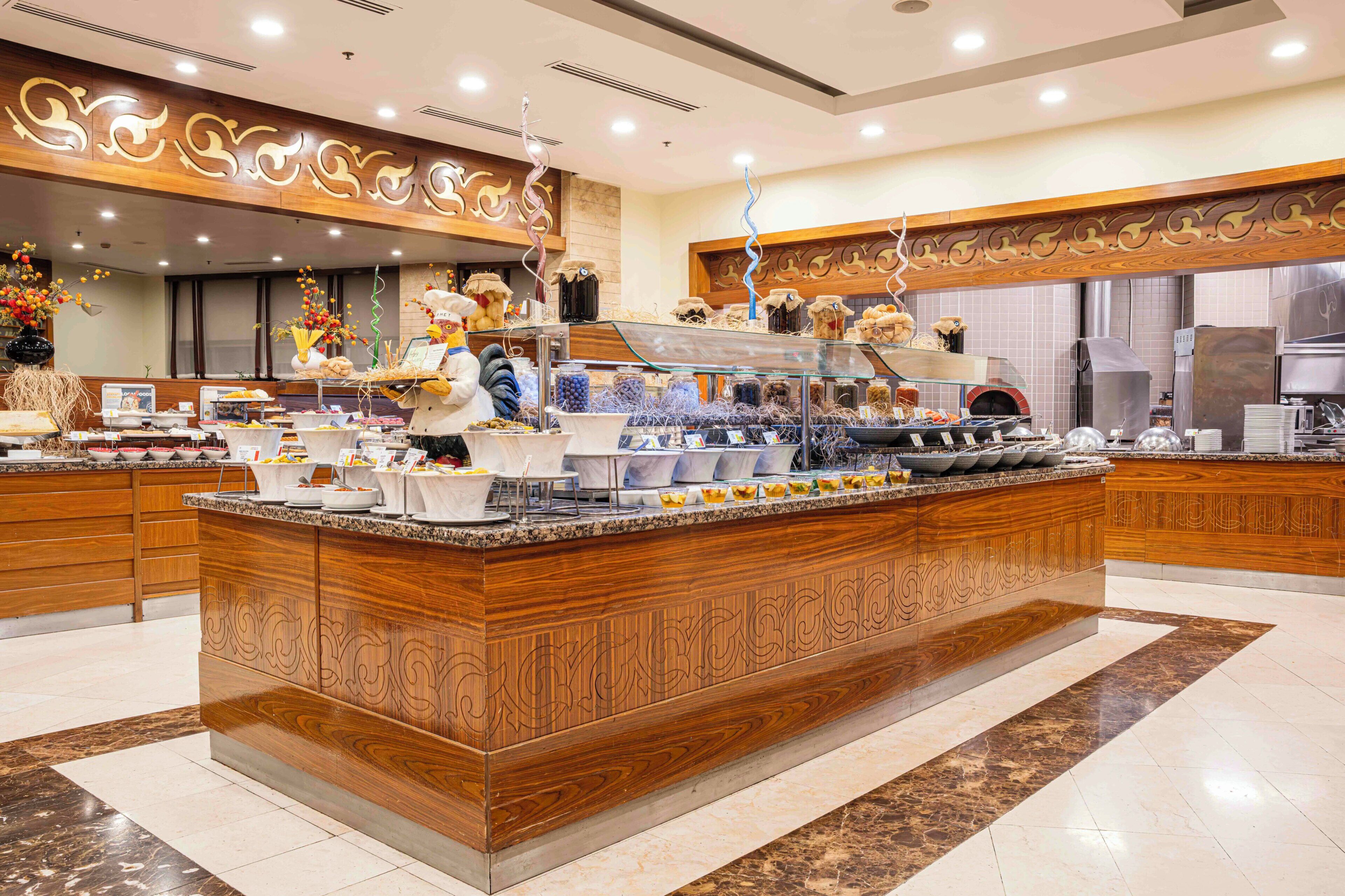 A spacious hotel lobby with a large central island, a reception desk, and a modern design.