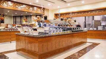 A spacious hotel lobby with a large central island, a reception desk, and a modern design.