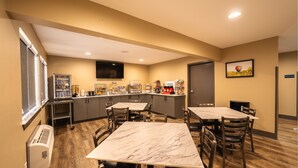 A hotel room with a dining area, a kitchen, and a TV. - Cobblestone Inn & Suites - Trenton (Trenton)