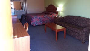 Une chambre d’hôtel avec un lit, un canapé, un bureau et une chaise.