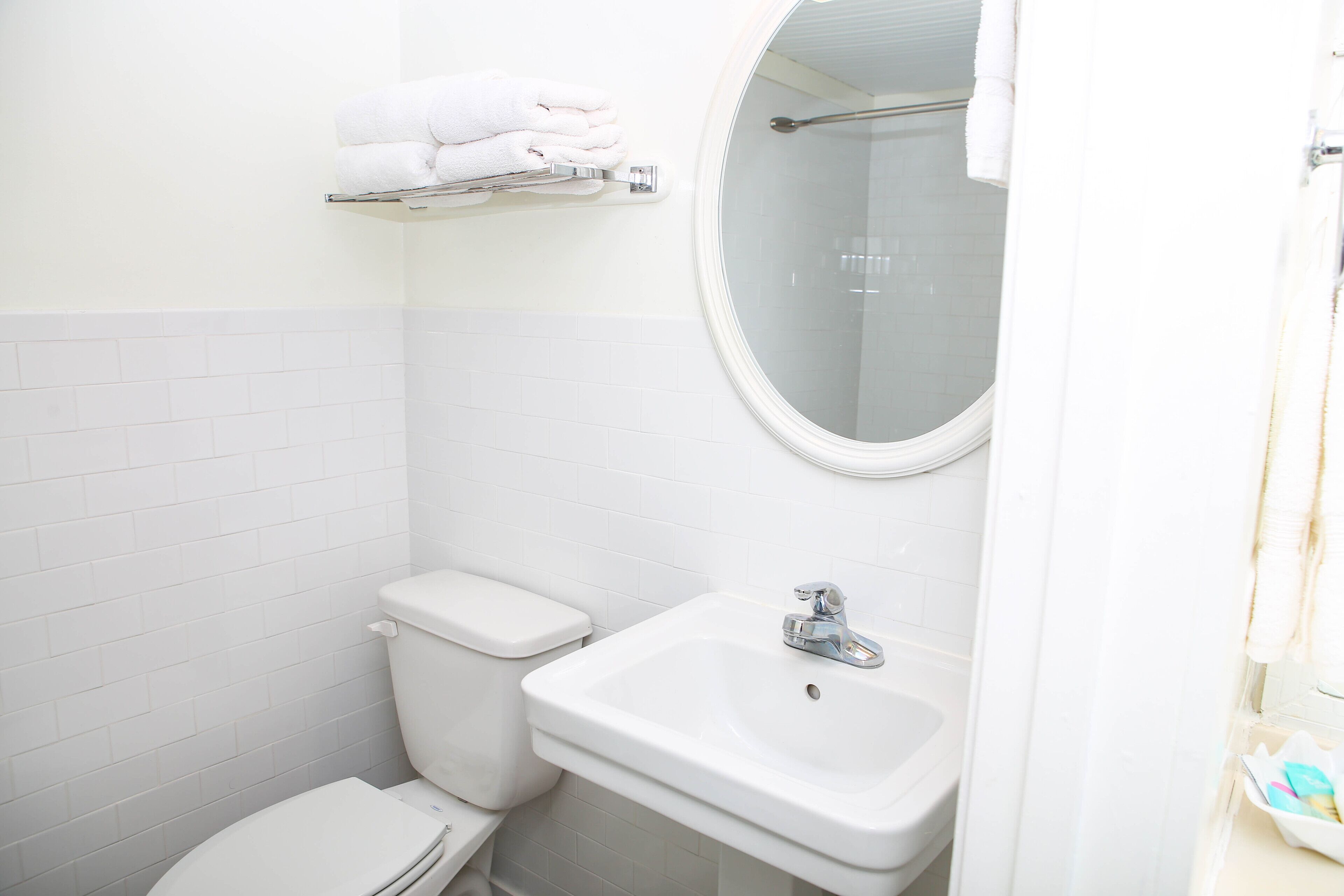 Un baño con inodoro, lavamanos y toallero.