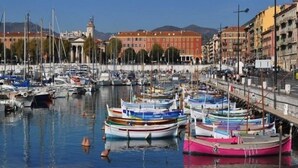 A marina with multiple boats docked, a bridge, and buildings in the background. - Relais Acropolis (Nice)