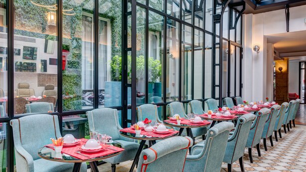 A restaurant with rows of tables and chairs, large windows, and a view of the outside.