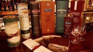 Varias botellas y cajas de whisky sobre una barra.