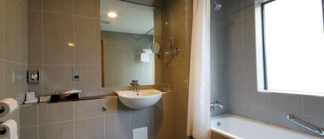 A modern bathroom with a toilet, sink, and bathtub.