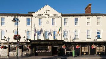 A building with a sign reading "TREACY'S HOTEL" and a restaurant named "TIMBER TOE'S BAR" below it.