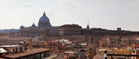 Un paisaje urbano con un edificio histórico destacado y una cúpula al fondo.