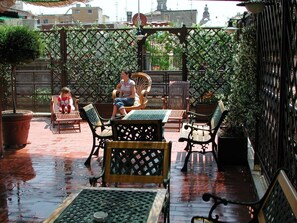 An outdoor patio with wooden furniture and a lattice fence.