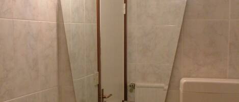 Un baño con un lavamanos blanco, un espejo y un inodoro.
