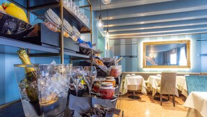 A restaurant with a buffet setup, including various food items and beverages. - Hotel Tiziano (Venice)