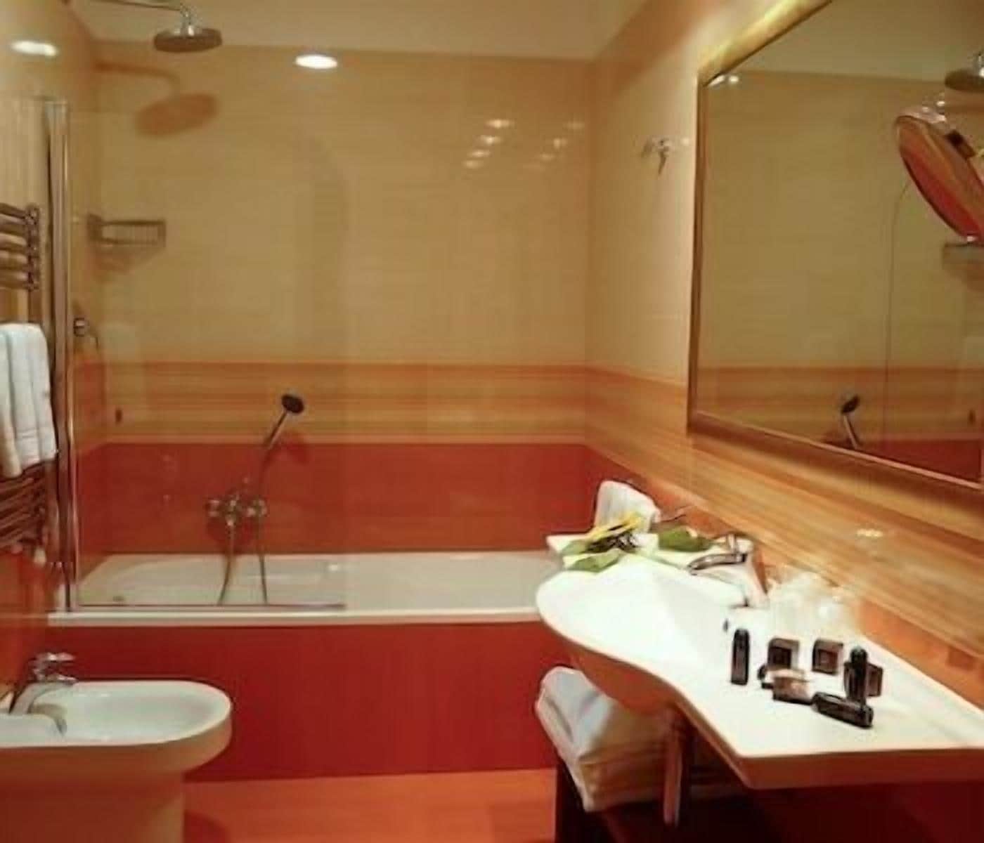 A bathroom with a bathtub, a sink, and a mirror.