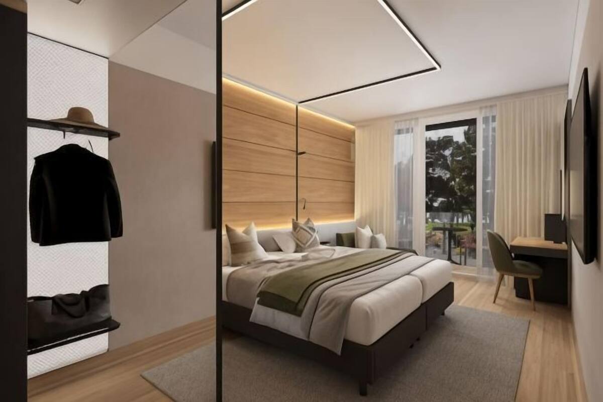 Un dormitorio moderno con una cama, un escritorio y una silla.