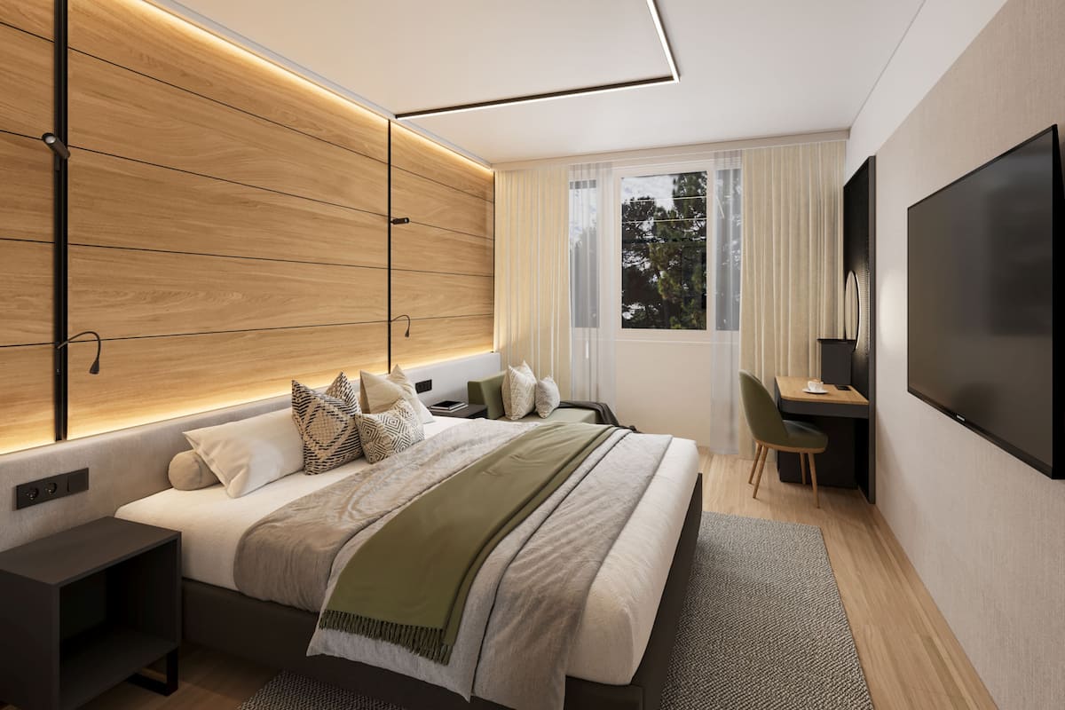 Un dormitorio moderno con una cama grande, mesitas de noche, un escritorio y un televisor.
