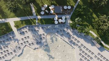 An aerial view of a resort with a pool area, sun loungers, and a covered seating area with umbrellas.